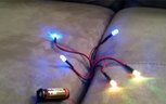 A few LEDs hooked up to Oznium's tiny "23A" 12 volt battery & battery holder.
